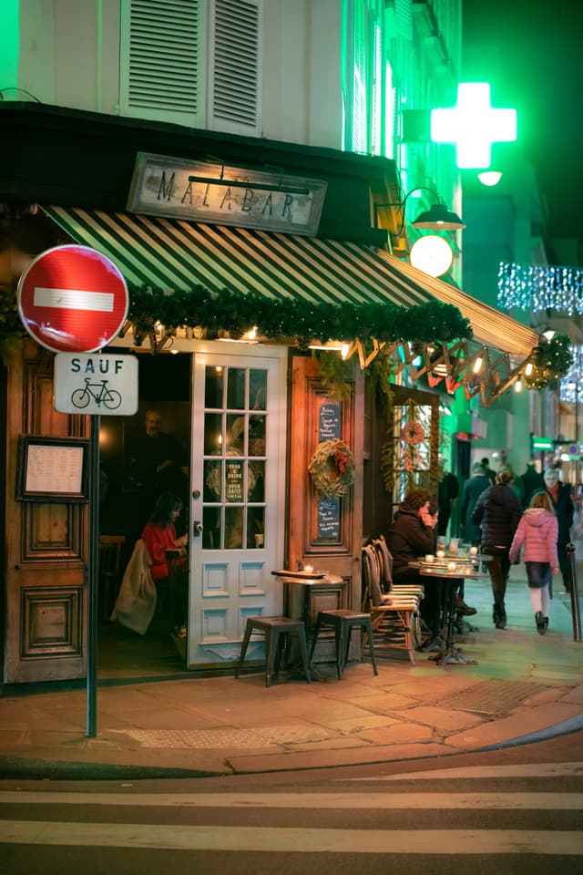 an exterior shot of a cafe on a corner in Paris